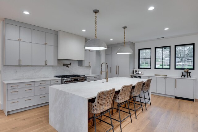 kitchen featuring a kitchen bar, tasteful backsplash, range, and a sink
