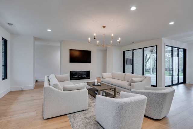 living room featuring light wood-style flooring, baseboards, a notable chandelier, visible vents, and recessed lighting