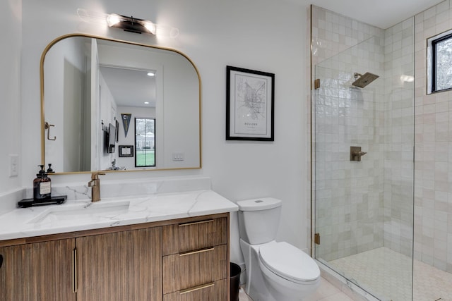 bathroom with vanity, toilet, and tiled shower