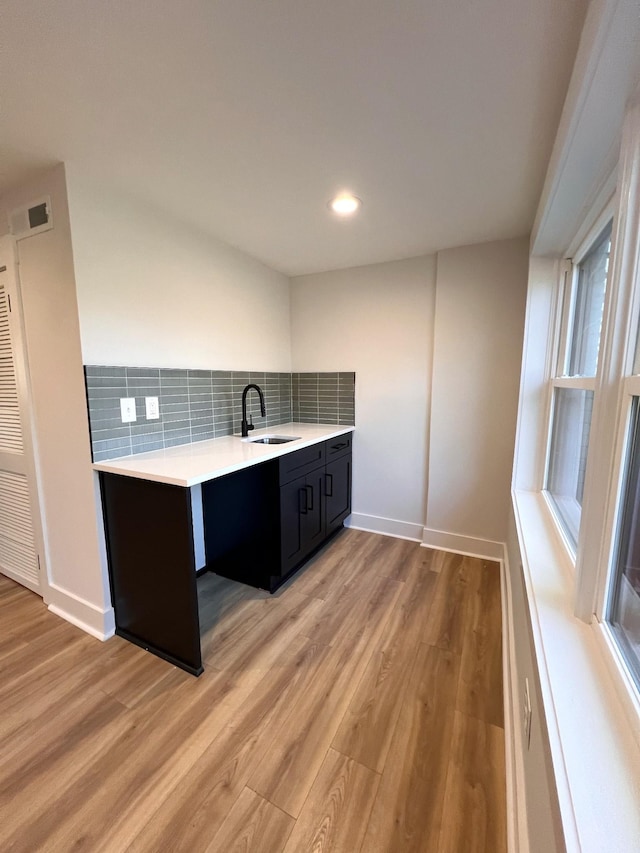 931 Downey Dr, Nashville, TN 37205 - kitchen with a sink, decorative backsplash, light wood-type flooring, light countertops, and dark cabinets