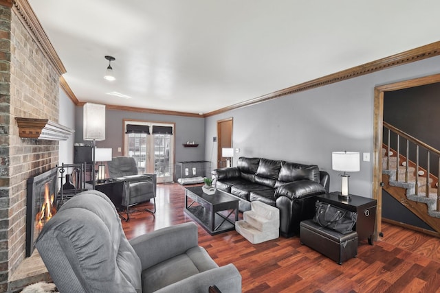 living area with stairway, ornamental molding, wood finished floors, and a fireplace