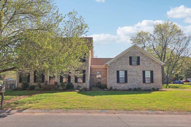 view of front facade featuring brick siding and a front yard