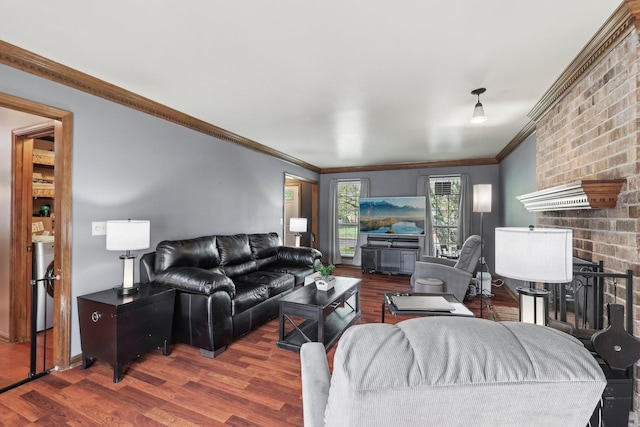 living room with crown molding, wood finished floors, baseboards, washer / clothes dryer, and a brick fireplace