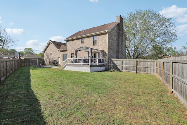 back of property with a fenced backyard, a chimney, and a yard