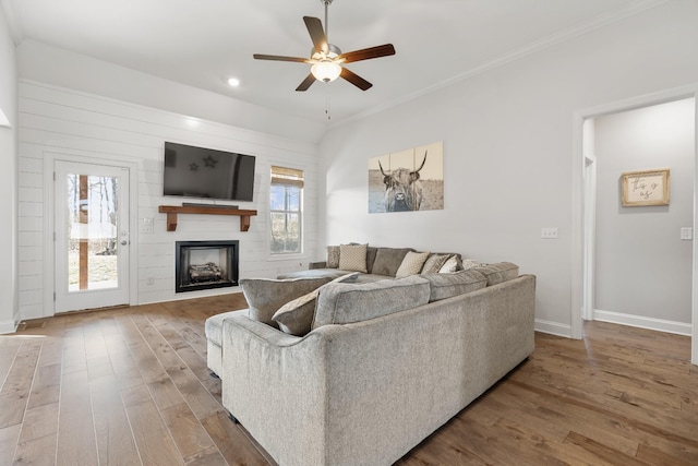 living area featuring baseboards, recessed lighting, wood finished floors, ceiling fan, and a fireplace