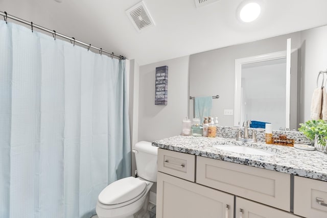 full bath with visible vents, curtained shower, vanity, and toilet
