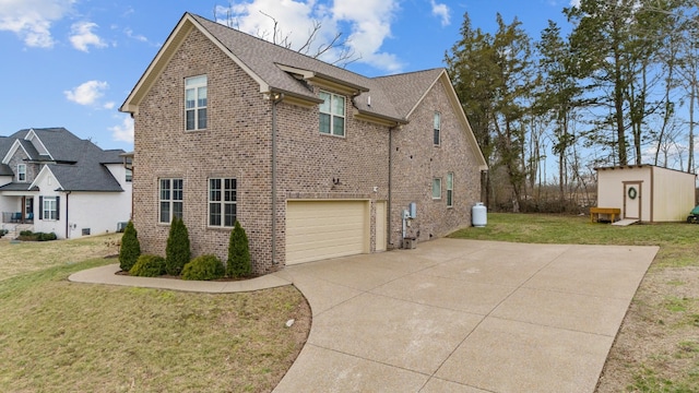 view of side of home featuring a storage shed, a yard, an attached garage, driveway, and brick siding