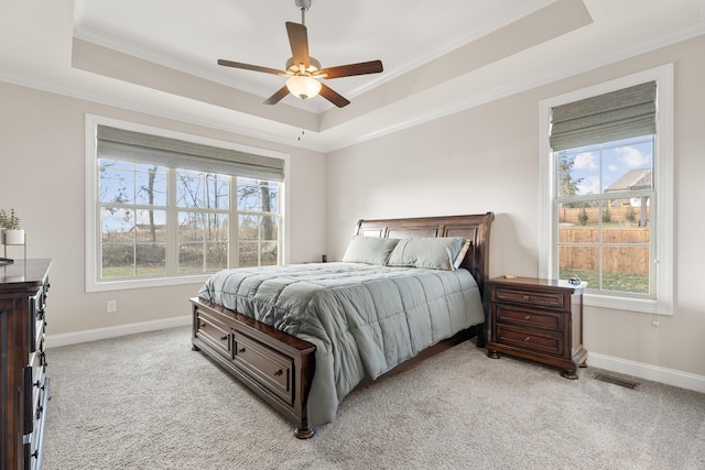 bedroom featuring a raised ceiling, visible vents, crown molding, and light colored carpet