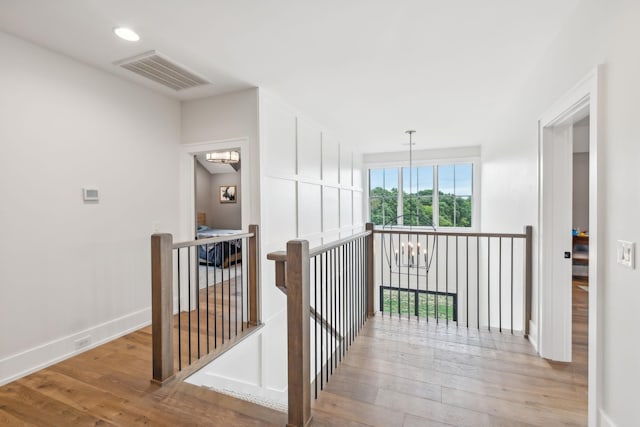 6490 Peytonsville Arno Rd, College Grove, TN 37046 - hallway with visible vents, baseboards, a chandelier, an upstairs landing, and wood finished floors
