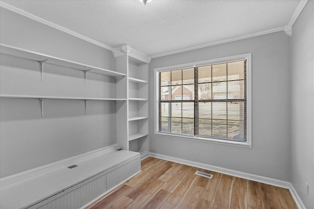 mudroom featuring ornamental molding, wood finished floors, a textured ceiling, and baseboards