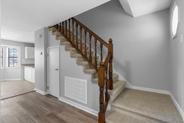 stairway featuring baseboards and wood finished floors