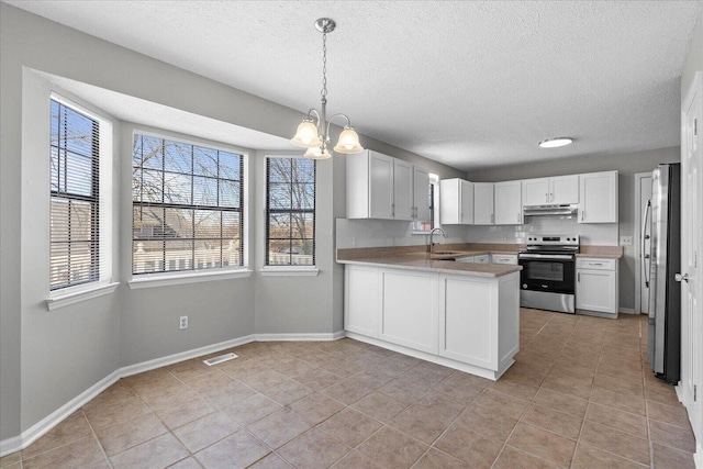 kitchen with appliances with stainless steel finishes, light tile patterned floors, a peninsula, a chandelier, and light countertops