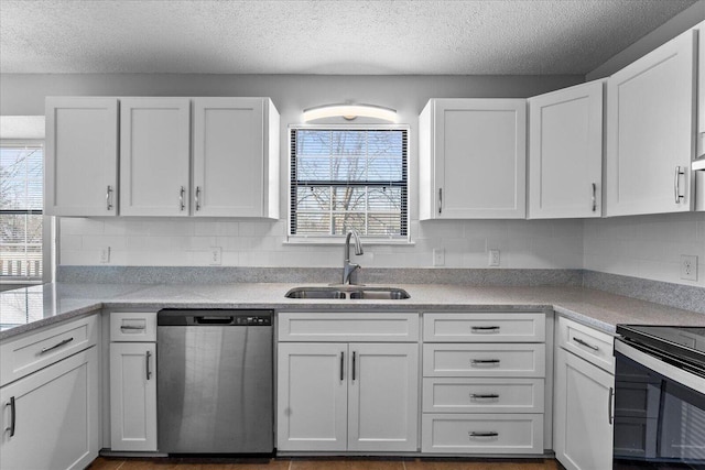 kitchen featuring appliances with stainless steel finishes, a sink, light countertops, white cabinetry, and a textured ceiling
