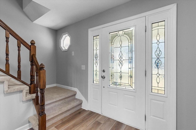 entryway featuring stairs, wood finished floors, and baseboards