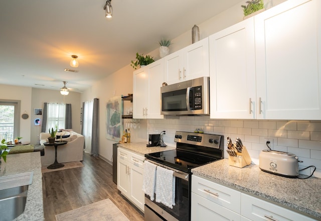 782 Riverfront Pkwy Unit 301, Chattanooga, TN 37402 - kitchen with backsplash, dark wood finished floors, white cabinetry, and stainless steel appliances