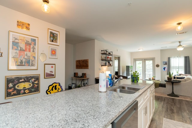 782 Riverfront Pkwy Unit 301, Chattanooga, TN 37402 - kitchen with stainless steel dishwasher, a sink, white cabinets, open floor plan, and dark wood finished floors