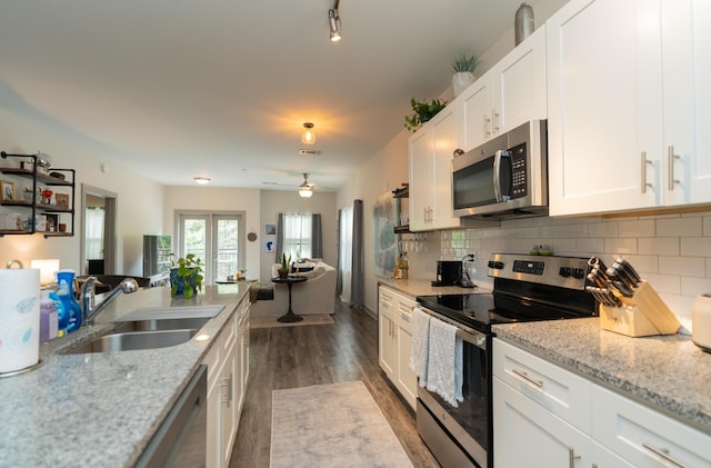 782 Riverfront Pkwy Unit 301, Chattanooga, TN 37402 - kitchen with white cabinets, a sink, tasteful backsplash, open floor plan, and appliances with stainless steel finishes