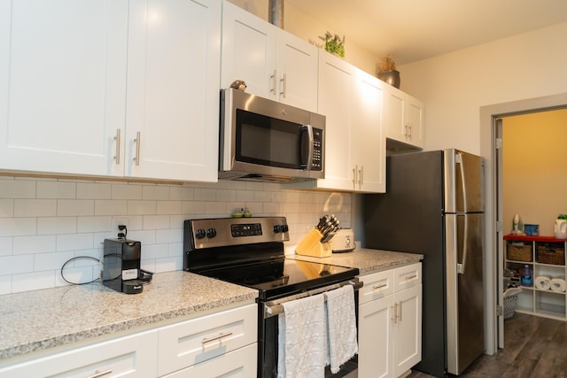 782 Riverfront Pkwy Unit 301, Chattanooga, TN 37402 - kitchen featuring light stone counters, decorative backsplash, white cabinetry, and stainless steel appliances