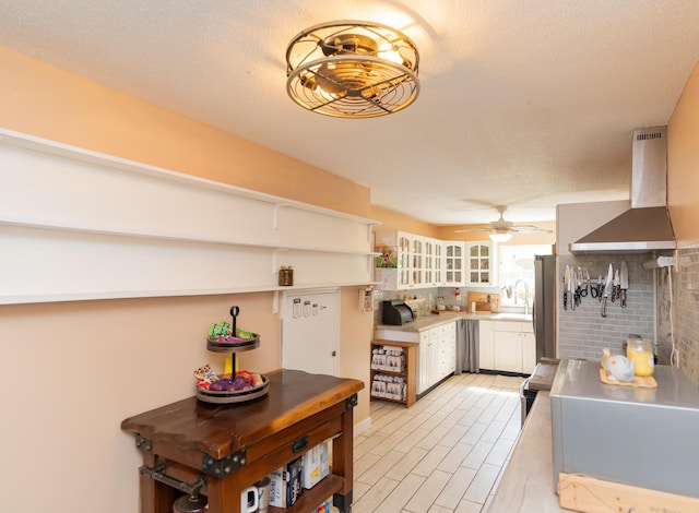 314 Williams Dr, Chattanooga, TN 37421 - kitchen featuring decorative backsplash, ceiling fan, light countertops, white cabinets, and wall chimney exhaust hood