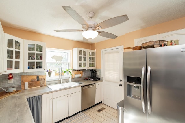 314 Williams Dr, Chattanooga, TN 37421 - kitchen featuring white cabinets, light countertops, a sink, decorative backsplash, and appliances with stainless steel finishes