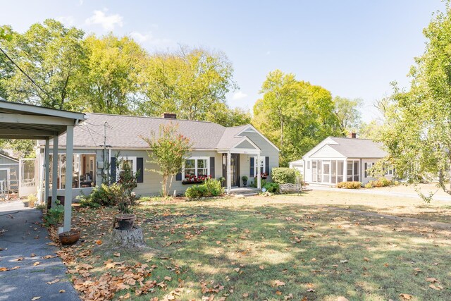 314 Williams Dr, Chattanooga, TN 37421 - view of front of house featuring a sunroom, a chimney, a front lawn, and a shingled roof