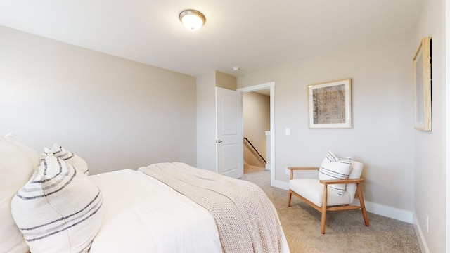 bedroom featuring light colored carpet and baseboards
