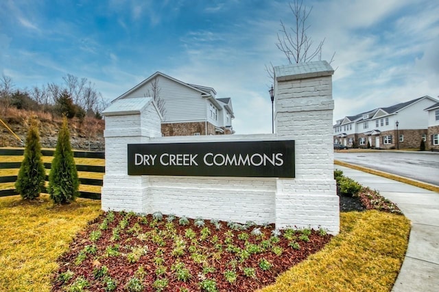 community sign featuring fence and a residential view