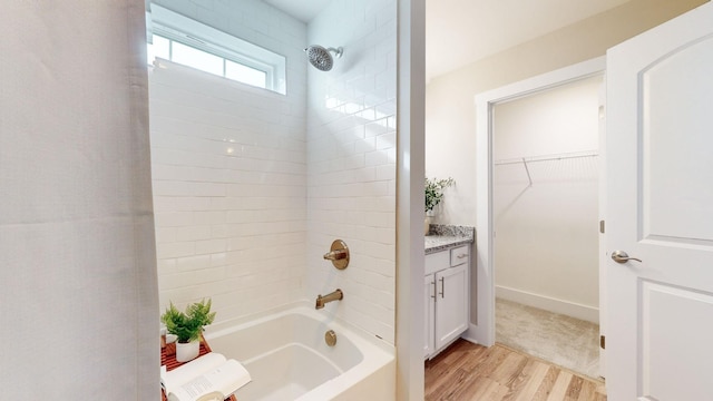 full bath featuring wood finished floors, bathing tub / shower combination, and vanity