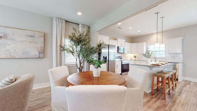 dining area with light wood-style flooring, recessed lighting, and baseboards