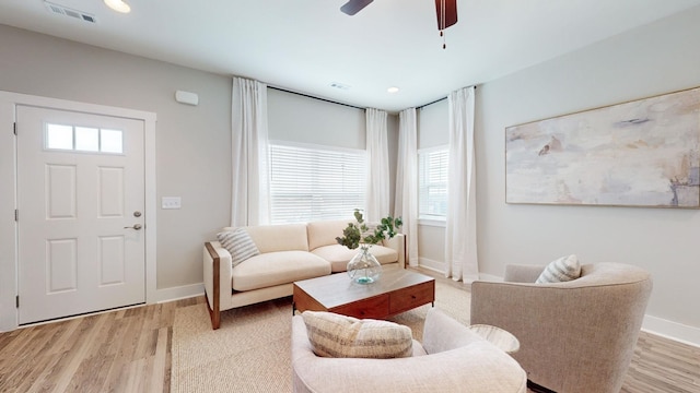 living area with light wood finished floors, baseboards, and ceiling fan