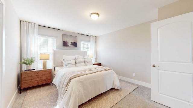 bedroom featuring baseboards and light colored carpet