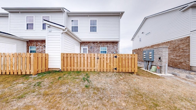 back of property featuring fence and brick siding