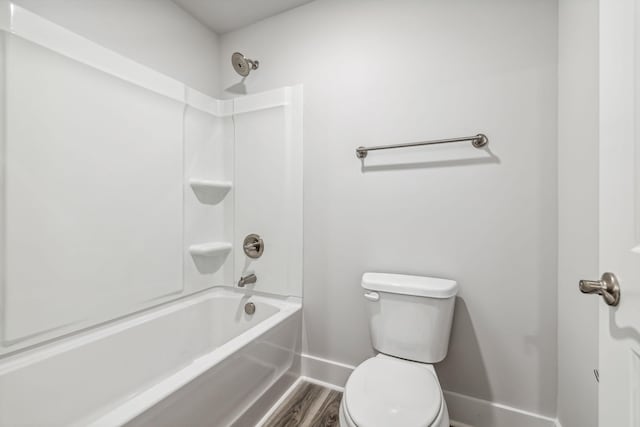 full bathroom featuring tub / shower combination, toilet, and baseboards