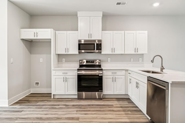 kitchen with white cabinetry, appliances with stainless steel finishes, a sink, and visible vents