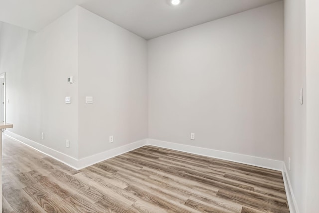 spare room featuring recessed lighting, light wood-style flooring, and baseboards
