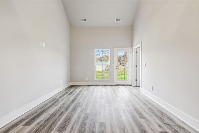 unfurnished room featuring baseboards, visible vents, and light wood-type flooring