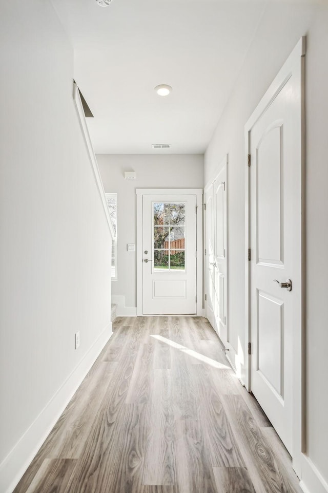 entrance foyer featuring baseboards, wood finished floors, and visible vents