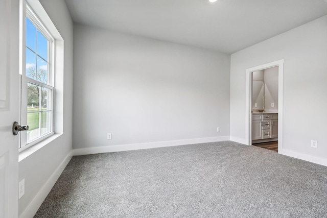 unfurnished room featuring baseboards and carpet