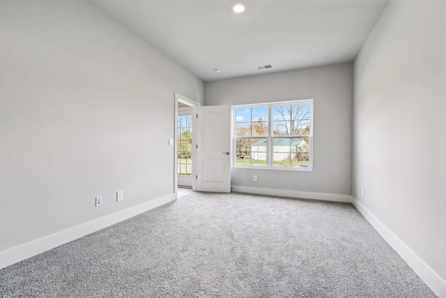unfurnished room with baseboards, visible vents, and carpet