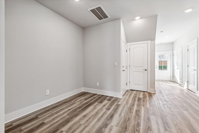 spare room featuring recessed lighting, wood finished floors, visible vents, and baseboards