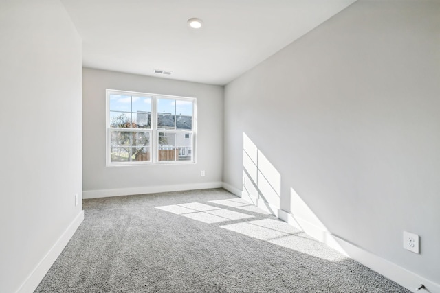 carpeted empty room with visible vents and baseboards
