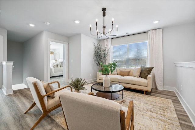 living area with wood finished floors, baseboards, recessed lighting, and a chandelier