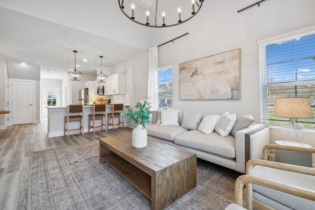 living room featuring recessed lighting, an inviting chandelier, and light wood-type flooring
