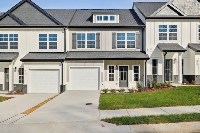 townhome / multi-family property featuring board and batten siding, driveway, and a garage