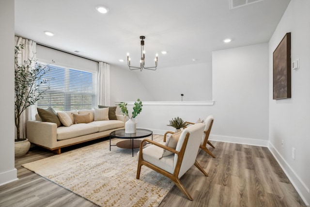living area with visible vents, baseboards, an inviting chandelier, recessed lighting, and wood finished floors