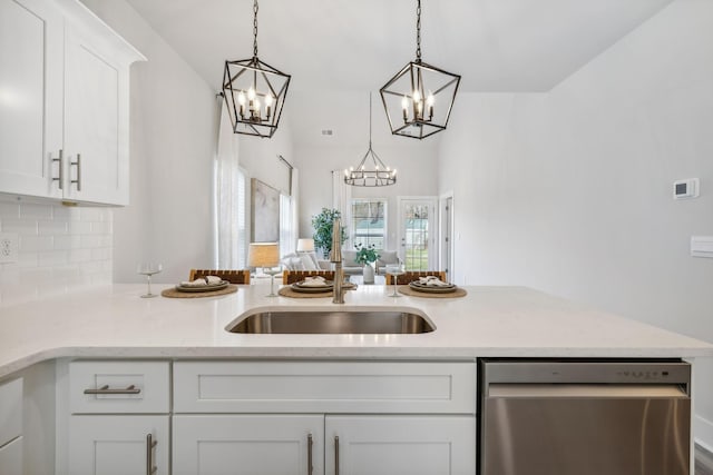 kitchen featuring white cabinets, backsplash, dishwasher, light stone countertops, and a chandelier