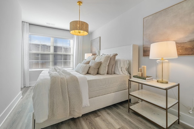 bedroom featuring baseboards and wood finished floors