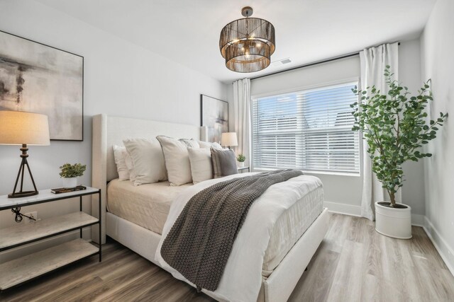 bedroom with baseboards and wood finished floors