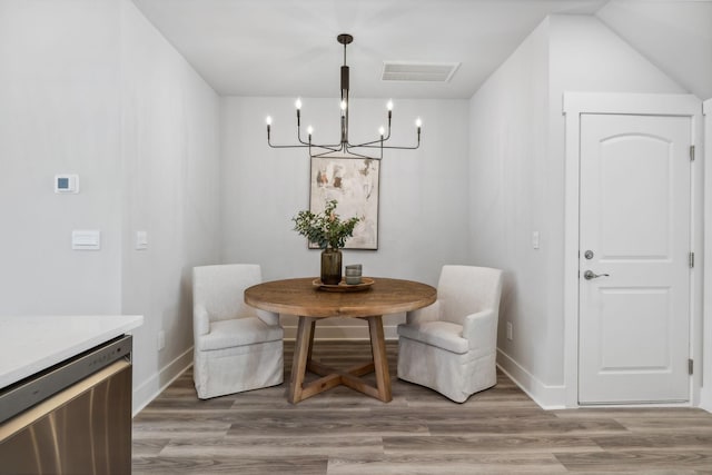 dining space featuring light wood-type flooring, visible vents, baseboards, and an inviting chandelier