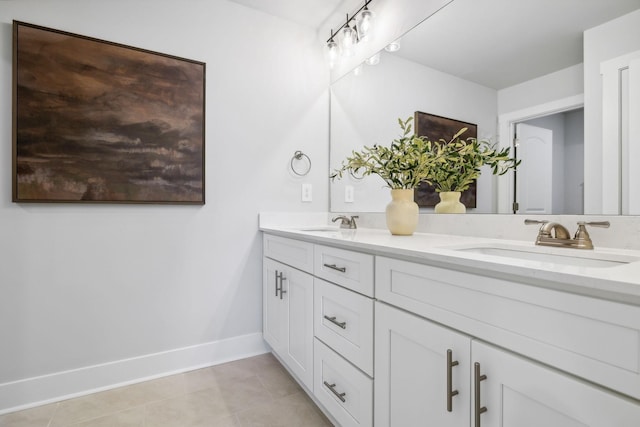 bathroom with double vanity, tile patterned floors, baseboards, and a sink